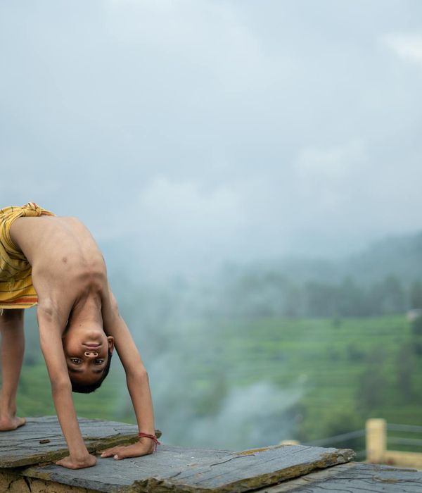 Woman practicing a basic yoga pose in a serene blue-gray environment.
